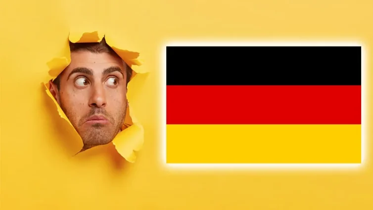 Hombre sorprendido junto a una bandera de Alemania.
