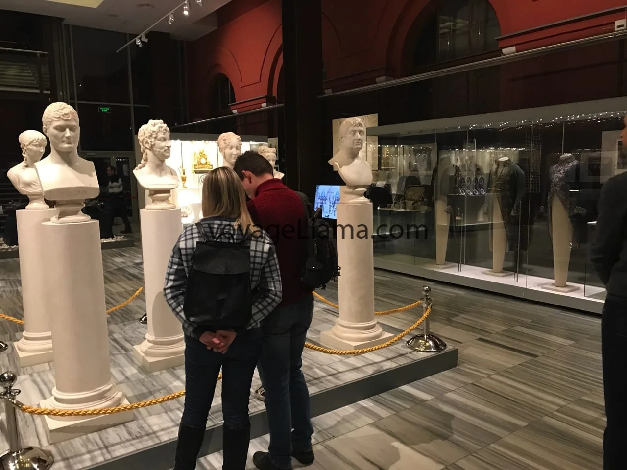 Visitante observando bustos históricos.