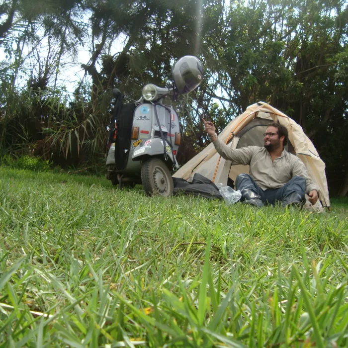 Fran Sepu acampando junto a su Vespa sobre el césped.
