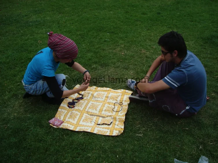 Dos amigos sentados sobre una manta de pícnic en un parque de Alemania.
